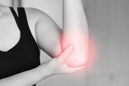 woman in black tank top holding on her elbow thumbnail