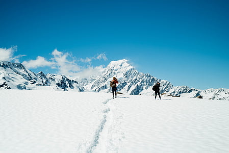 two people walking on snowy mountain during daytime thumbnail