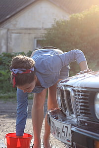 woman holding a bucket filled with soap while washing a BMW car thumbnail