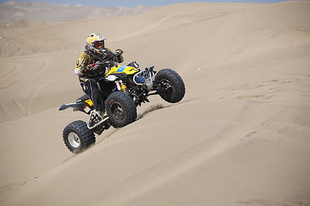 person riding on ATV on desert field during daytime thumbnail