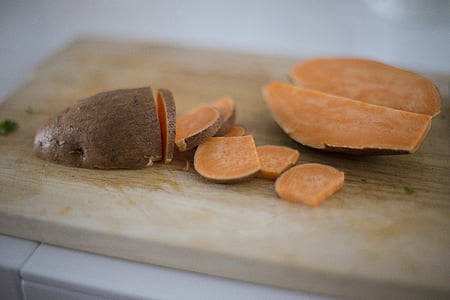 sliced sweet potatoes on beige wooden chopping board thumbnail