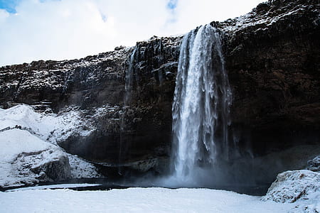 waterfalls near snow field during daytime thumbnail