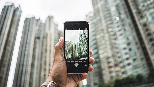 person holding black iPhone 7 capturing photo of high-rise building thumbnail