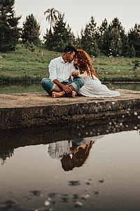 couple sitting near body of water thumbnail