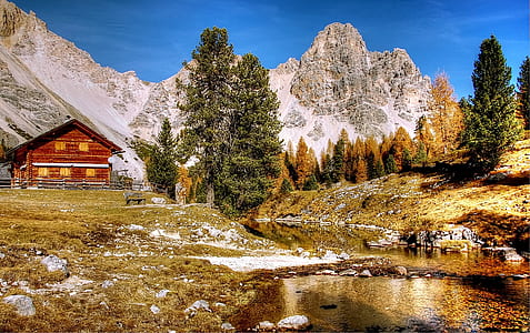 landscape photography of mountains near red house thumbnail
