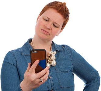 woman wearing blue chambray shirt holding smartphone thumbnail