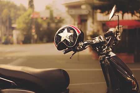 black motor scooter with black helmet thumbnail