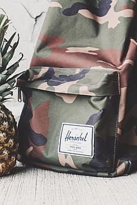 woodland camouflage Herschel backpack beside pineapple fruit thumbnail