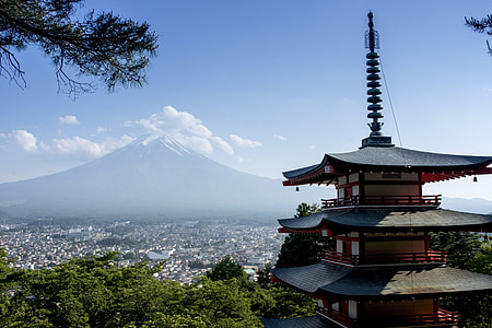 brown and white pagoda in front of volcano at daytime thumbnail