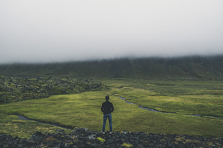 person in black long-sleeved top standing on mountain during daytime thumbnail