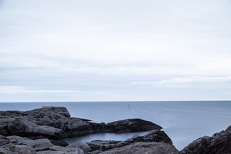 gray rock formation beside body of water thumbnail