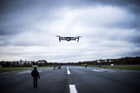 turned-on gray and red quadcopter drone on air thumbnail
