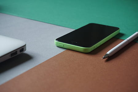 turned off green iPhone 5c on top of brown wooden furniture thumbnail
