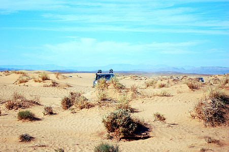 black vehicle on sand during daytime thumbnail