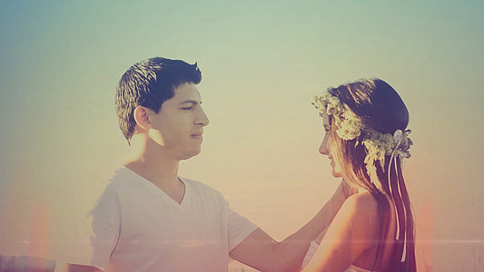man wearing white v-neck shirt in front of girl with white strapless dress photo thumbnail