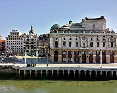white and brown concrete buildings near calm body of water thumbnail