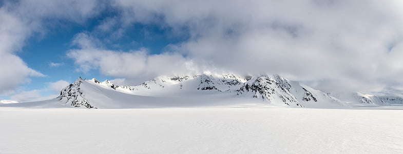 mountain covered by snow under white clouds at daytime thumbnail