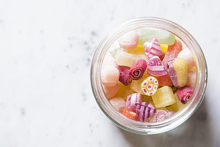 round clear candy dish with assorted-color gummy candies on white surface thumbnail
