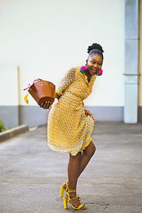 Woman in Pink Dress Holding Brown Bag Standing thumbnail