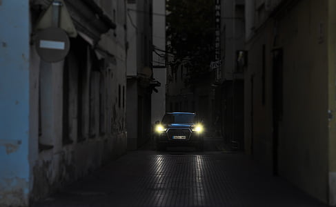 car on road between concrete building thumbnail