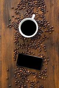 white teacup with coffee beside Android smartphone thumbnail