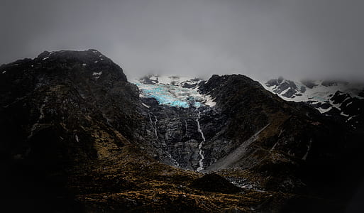snow covered mountains under cloudy skies thumbnail