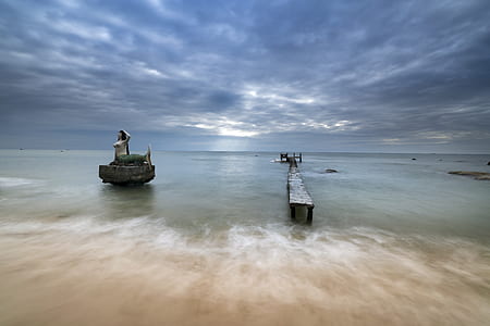 black wooden dock and boat on body of water at daytime thumbnail