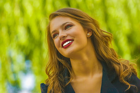 close up photograph of woman in black notched lapel top thumbnail