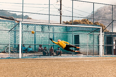 photo of goal keeper jumping and catching soccer ball thumbnail