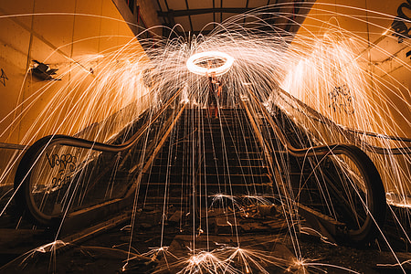 man doing fire poi dance on escalator thumbnail