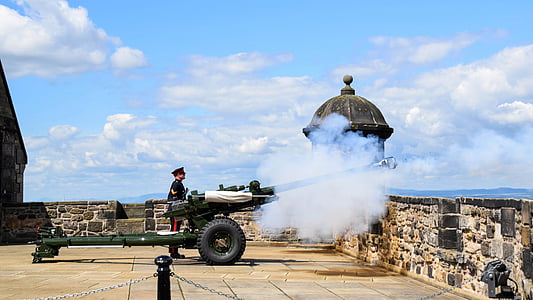 man standing beside canon during daytime thumbnail