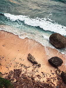 ocean waves on seashore with black boulders thumbnail