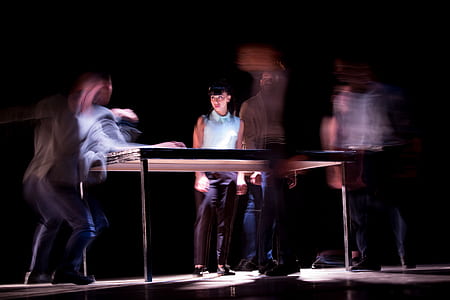 woman standing near brown and black wooden table thumbnail