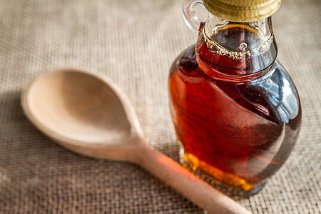 clear glass bottle with liquid beside wooden spatula thumbnail