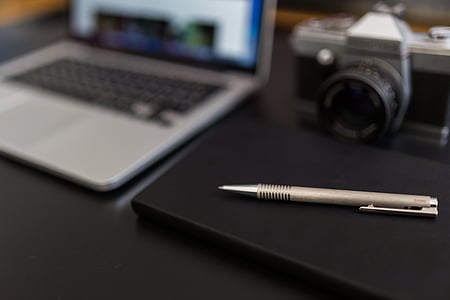 silver MacBook and gray retractable pen thumbnail