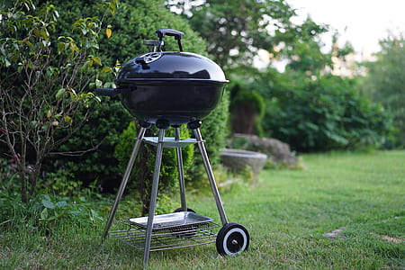 black steel charcoal grill beside green leafed plant thumbnail