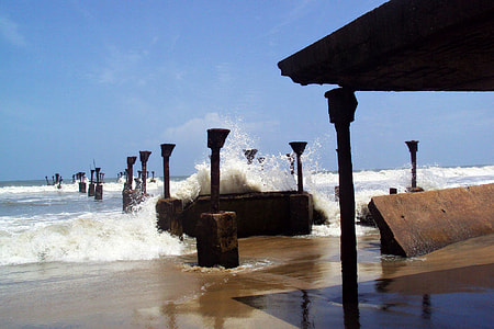 wave splashing on dock poles during daytime thumbnail