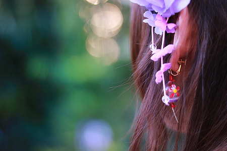 purple and pink petal flowers on woman's head under sunny sky thumbnail