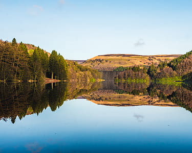 landscape photo of mountain and trees with reflection across body of water thumbnail