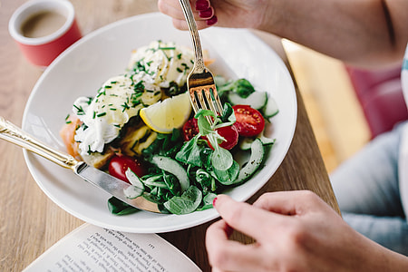 Woman eating breakfast and reading a book thumbnail