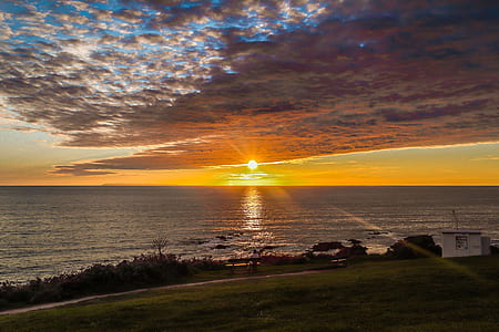 photo of roadway near sea during golden hour thumbnail