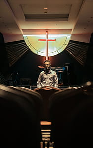 man in gray dress shirt standing at the front of cross thumbnail