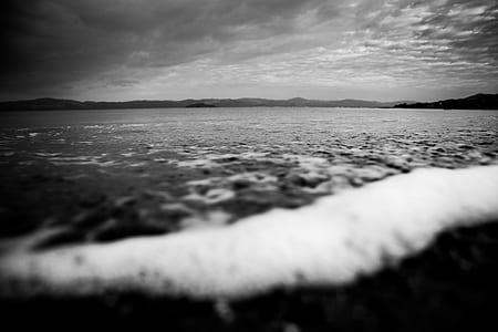 grayscale photo of water foam on sand thumbnail