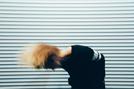 woman wearing black top bowing near white background thumbnail