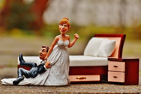 girl wearing white wedding dress holding man's black jacket figurines thumbnail