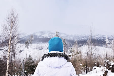 person standing near withered tree covered by snow thumbnail