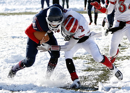 two male playing American football game at the snowfield thumbnail