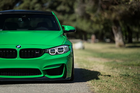 selective focus photography of green BMW 3-series on road near trees at daytime thumbnail