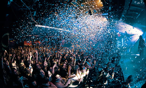 group of people watching concert with confetti above thumbnail