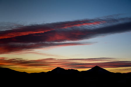 silhouette of mountain under cloudy sky at dawn thumbnail